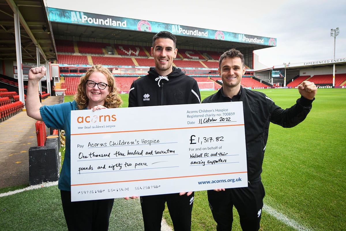 Walsall FC holding up a donation check for Acorns