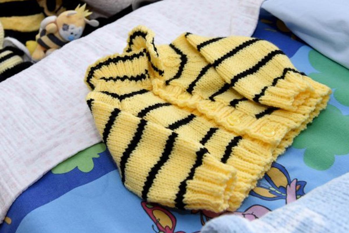 Baby jumper displayed on a bed.