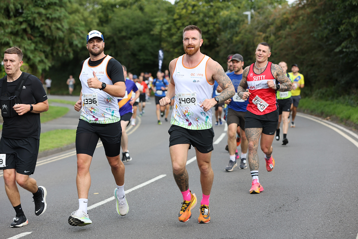 Two Acorns runners smiling at the camera mid-run