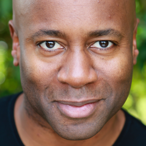 A man's headshot, smiling at the camera