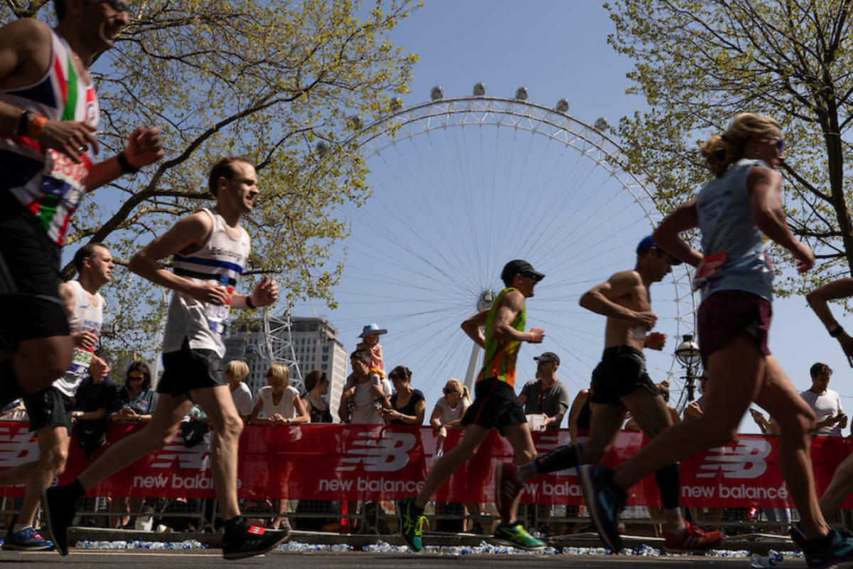 Runners running past The London Eye at the London Marathon.
