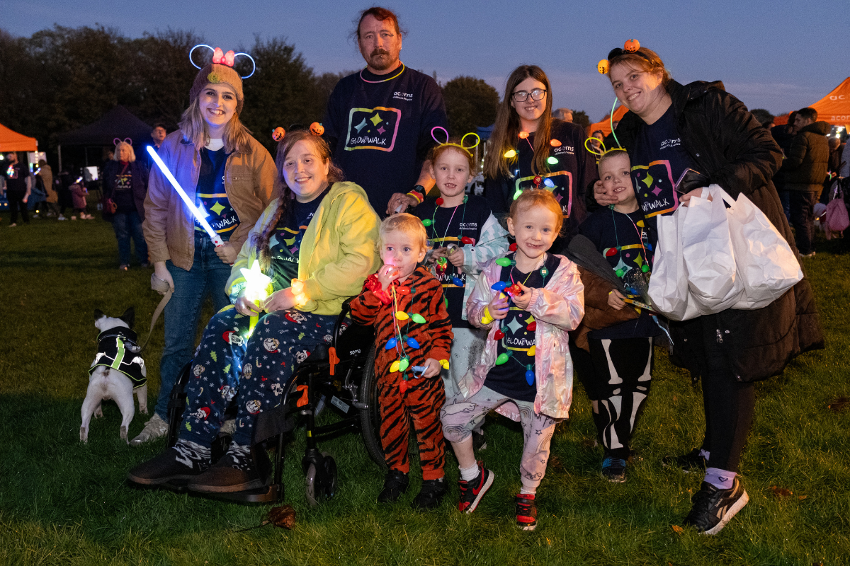A group of people all wearing glow stick accessories and one is holding a light stick.
