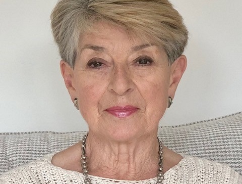 An older woman looks at the camera