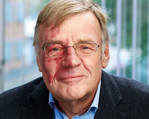 An older man smiling at the camera
