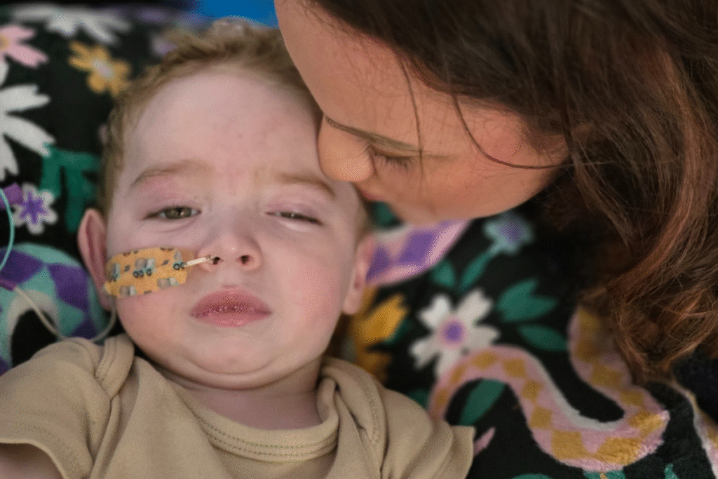 A young boy with a tube going into his nose.