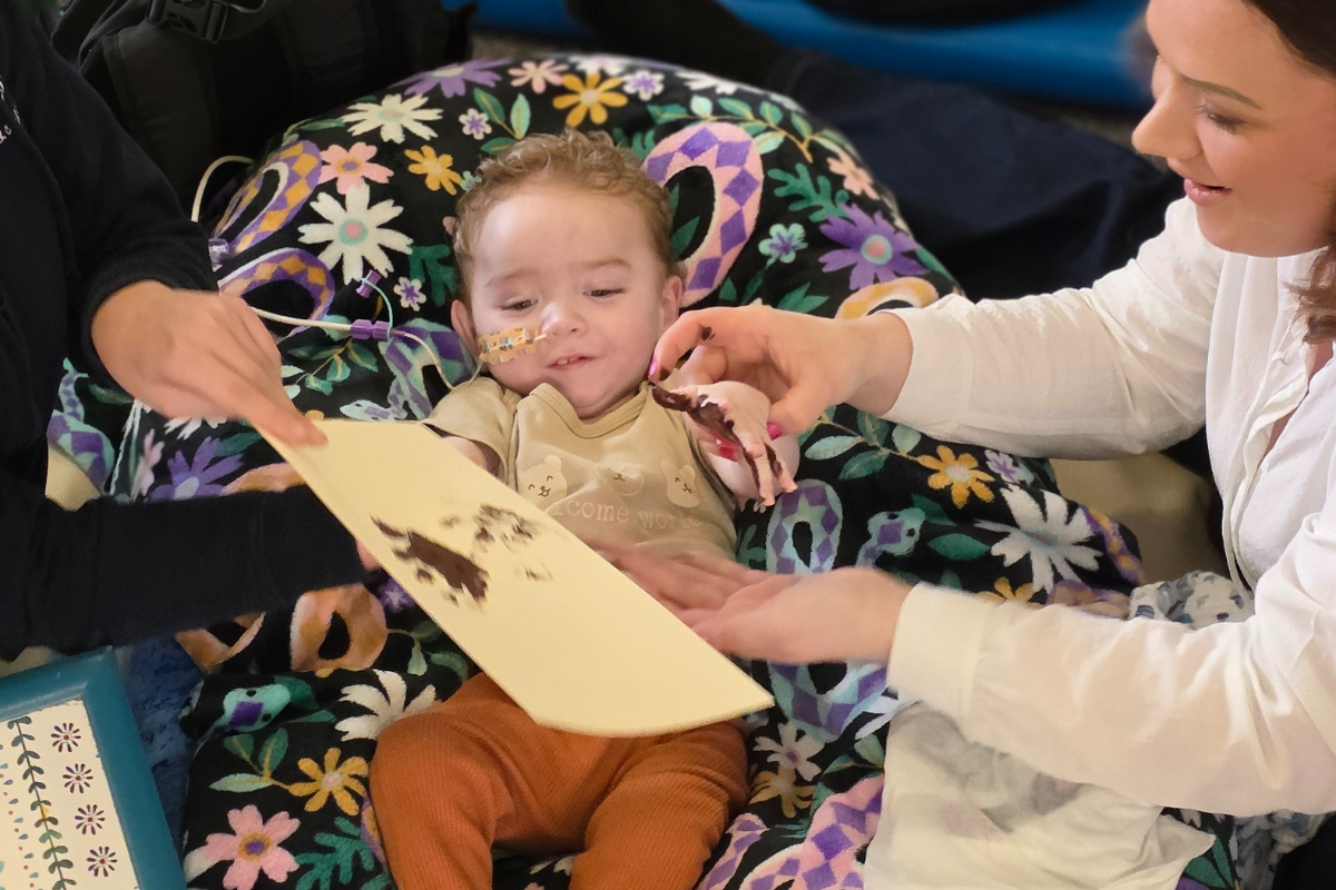 A little boy making a thank you card.