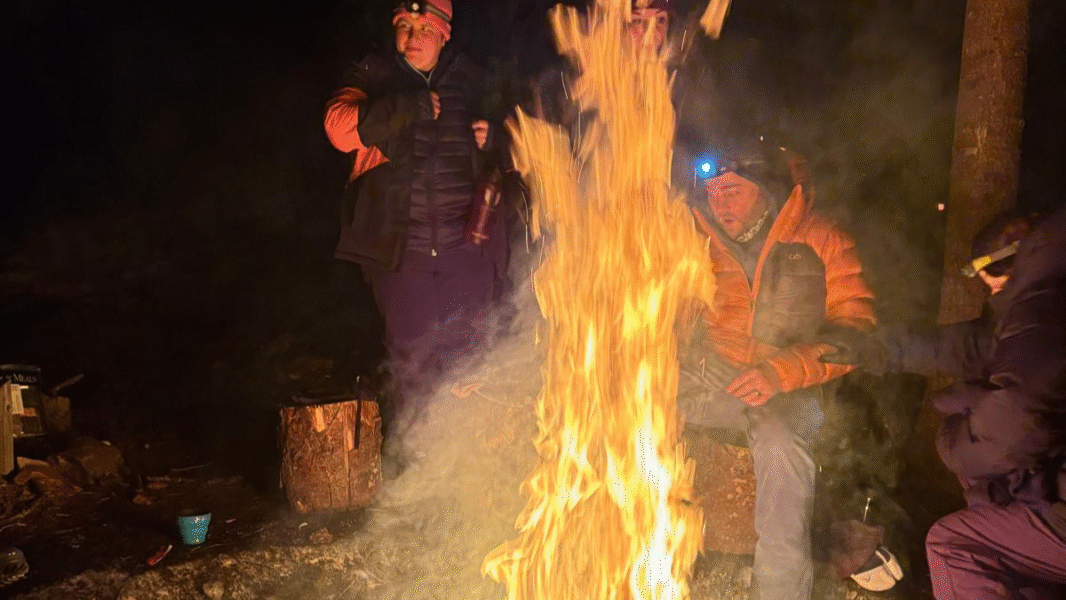 Two people sat behind a large fire.