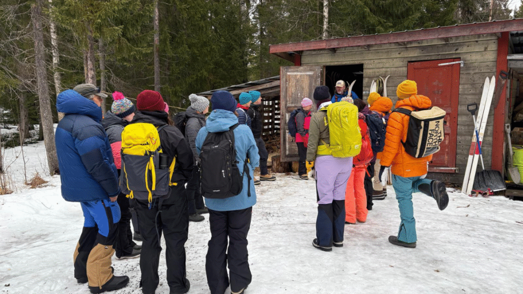 A group of people wearing coats and backpacks in the snow.