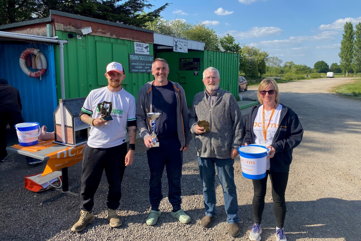 Three men and one woman stood outside, each holding a different item.