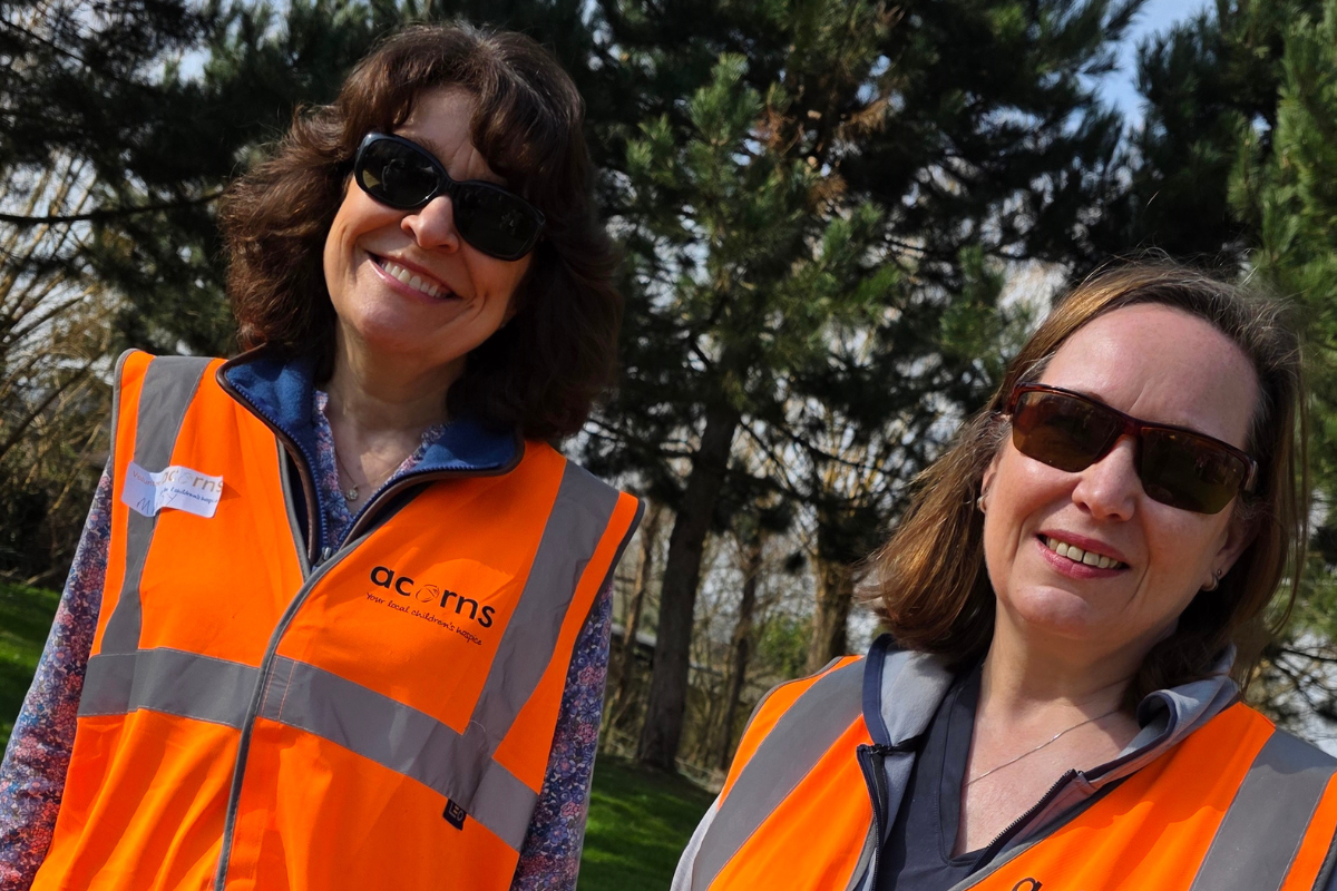 Two women both wearing sunglasses and orange hi vis jackets
