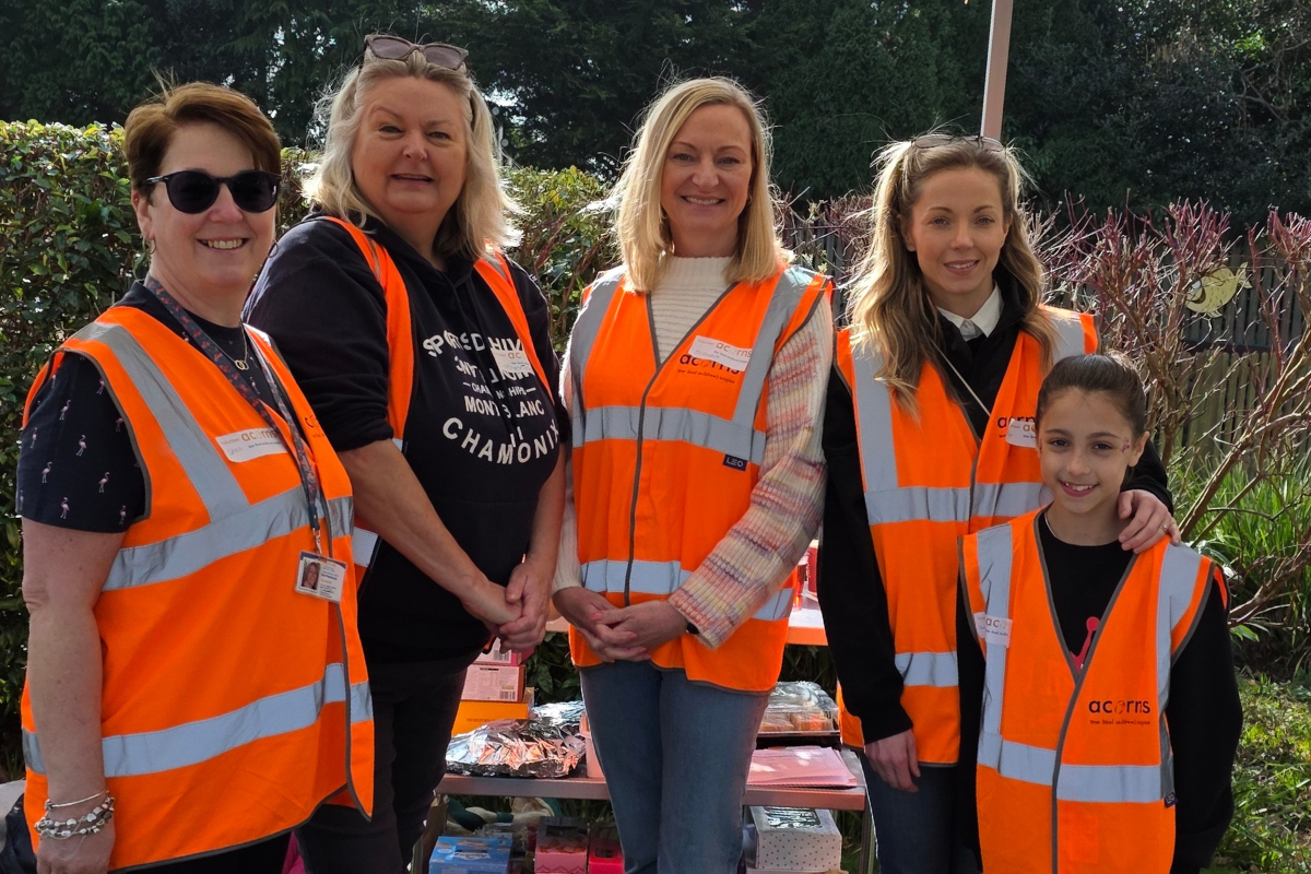 Four women and a young girl wearing orange hi vis jackets.