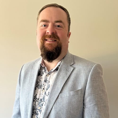 Gareth Harvey 500x500 A man in smart clothing smiles at the camera