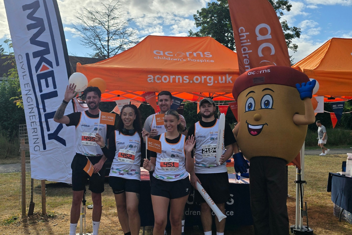Five Acorns runners wearing Run Solihull vests with Alex the Acorn mascot.